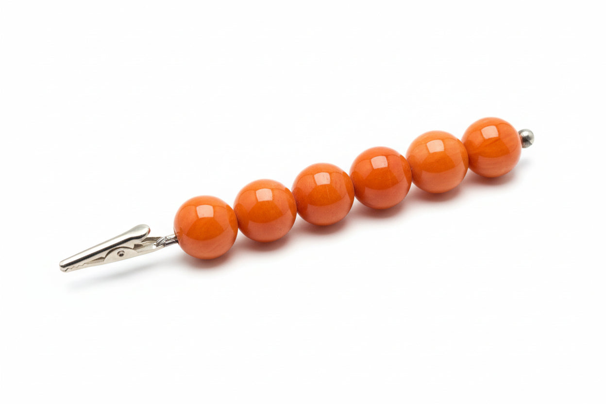 Beaded tie clip with orange beads on a white background
