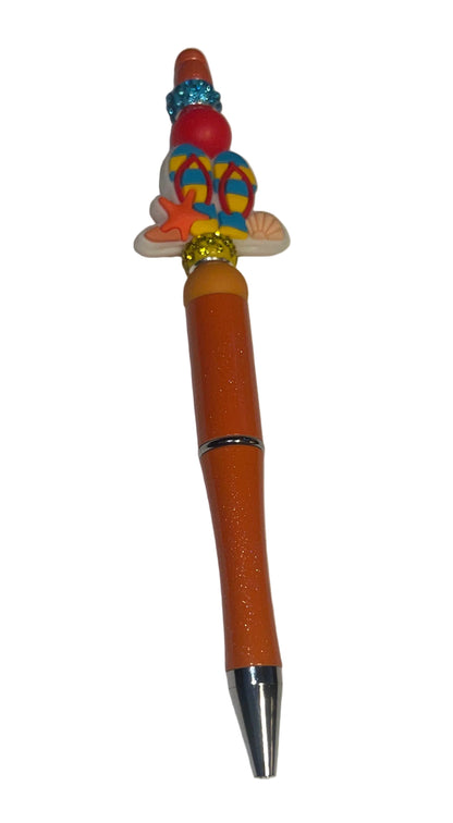 Handcrafted orange beaded pen with a colorful flip-flop charm by E-monae Jewels.