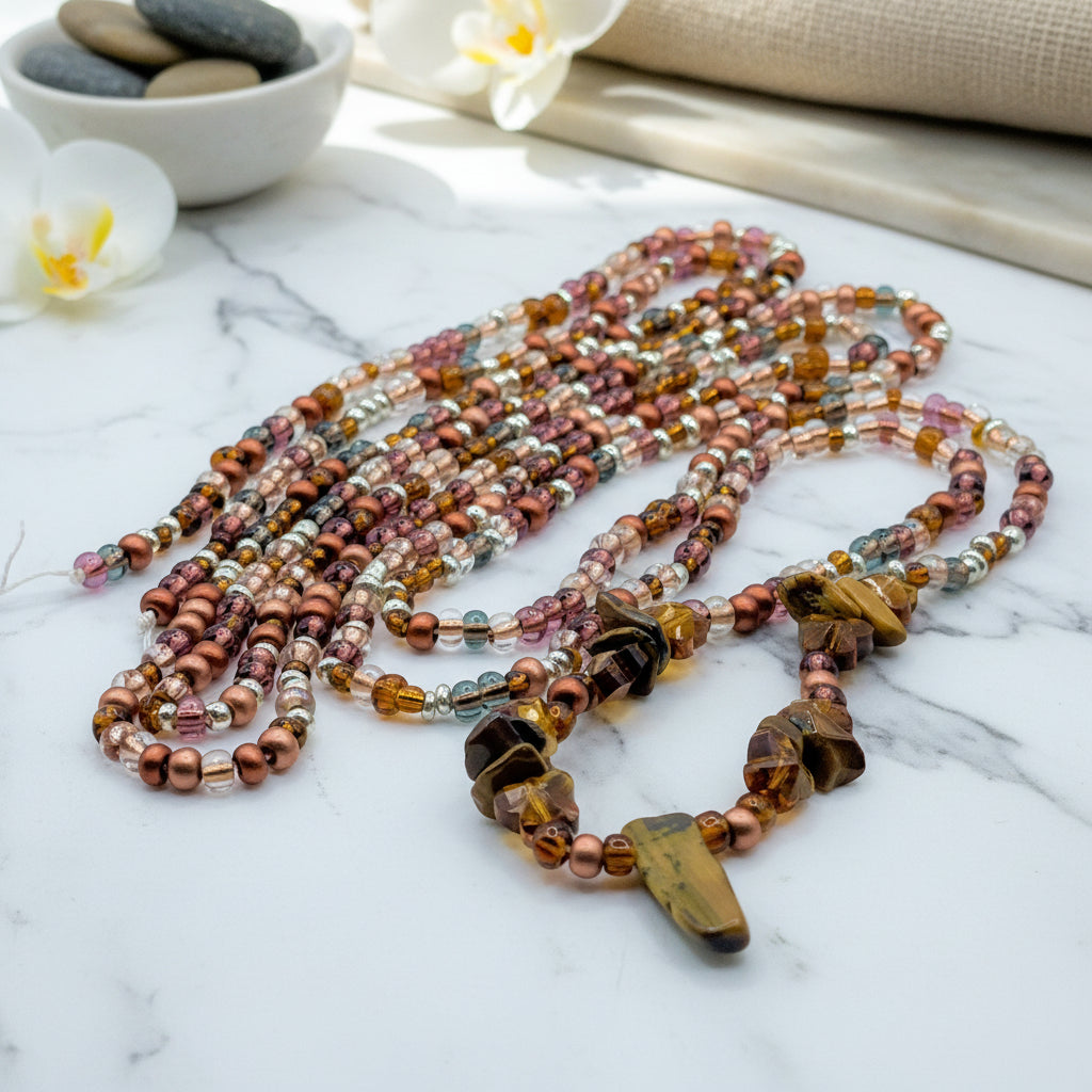 Ground your energy with our Earth tie-on waist beads. Features 55 inches of bronze and silver beads with a Tiger's Eye shield for protection and stability.