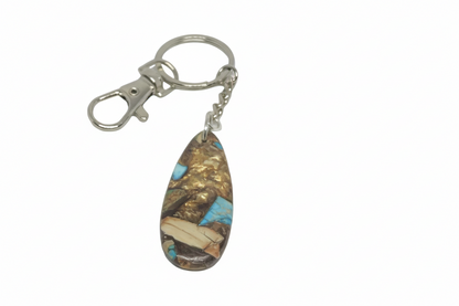 Handcrafted teardrop-shaped composite turquoise gemstone keychain with a copper-tone matrix on a silver keyring with vintage-style brass keys.