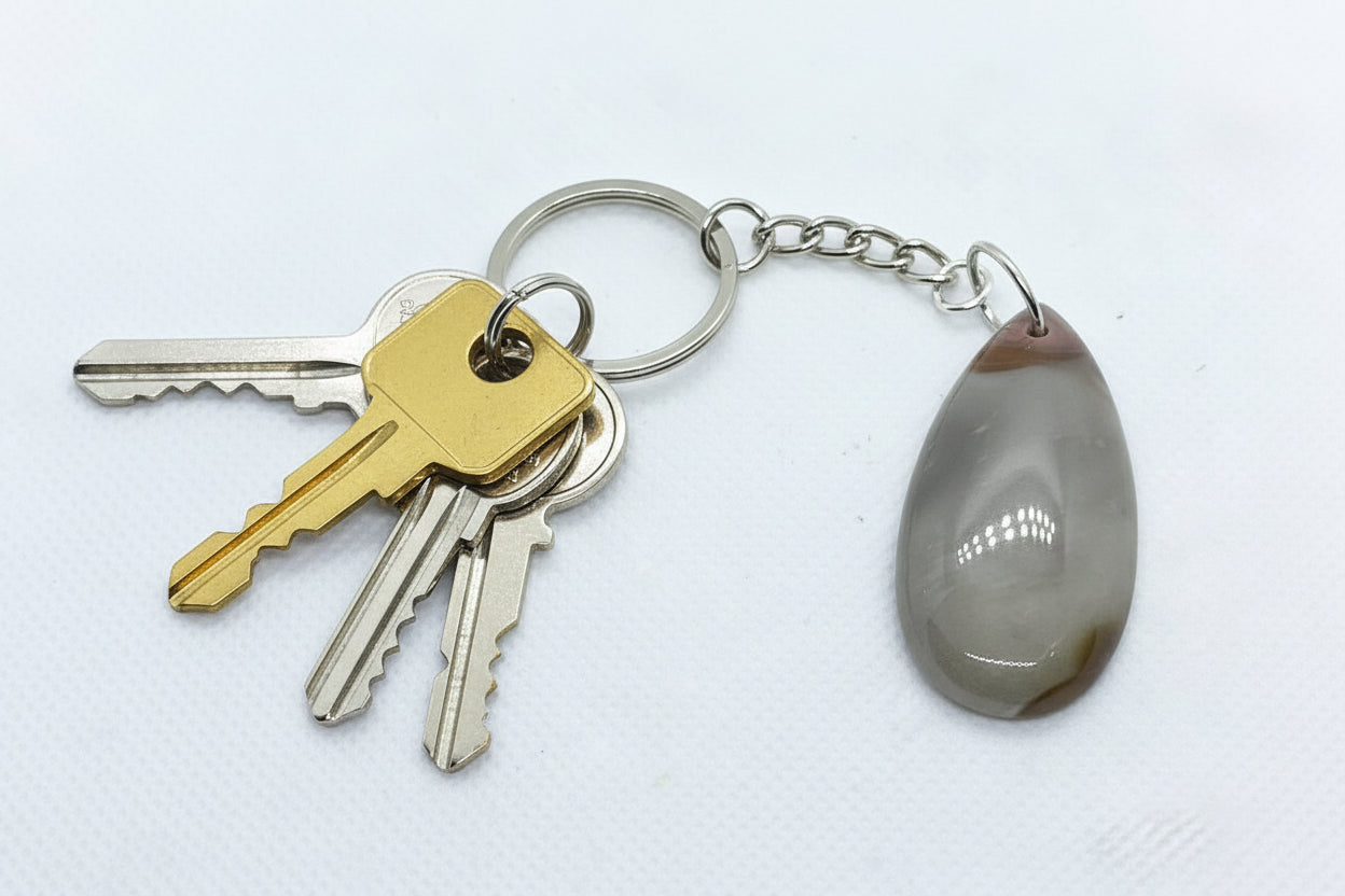 Handcrafted teardrop-shaped natural Banded Agate gemstone keychain on a silver-toned chain with keys.