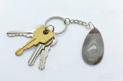 Handcrafted teardrop-shaped natural Banded Agate gemstone keychain on a silver-toned chain with keys.